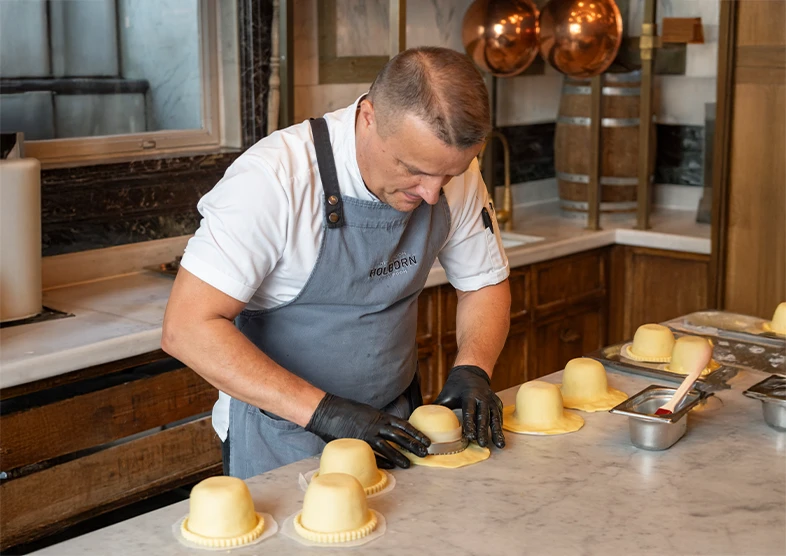 A chef makes his famous pies for The Pie Room
restaurant at The Rosewood in Holborn. The
kitchen is clean and modern with marble
worktops and copper pans hanging in the
background. 